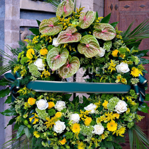 Corona funebre in armonia di colore sul verde.